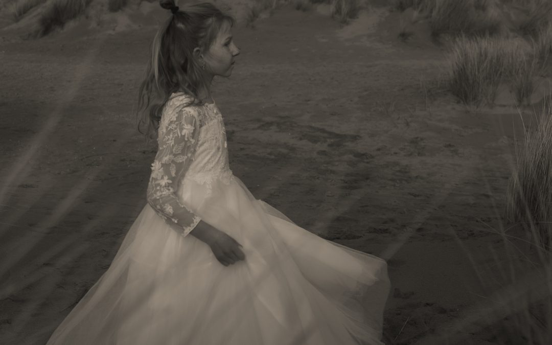 Meisje in witte jurk loopt door de duinen tijdens een fotoshoot bij zonsondergang – dromerige bruidsfotografie ByIris vanderZwan in het Westland, 's Gravenzande, regio Den Haag