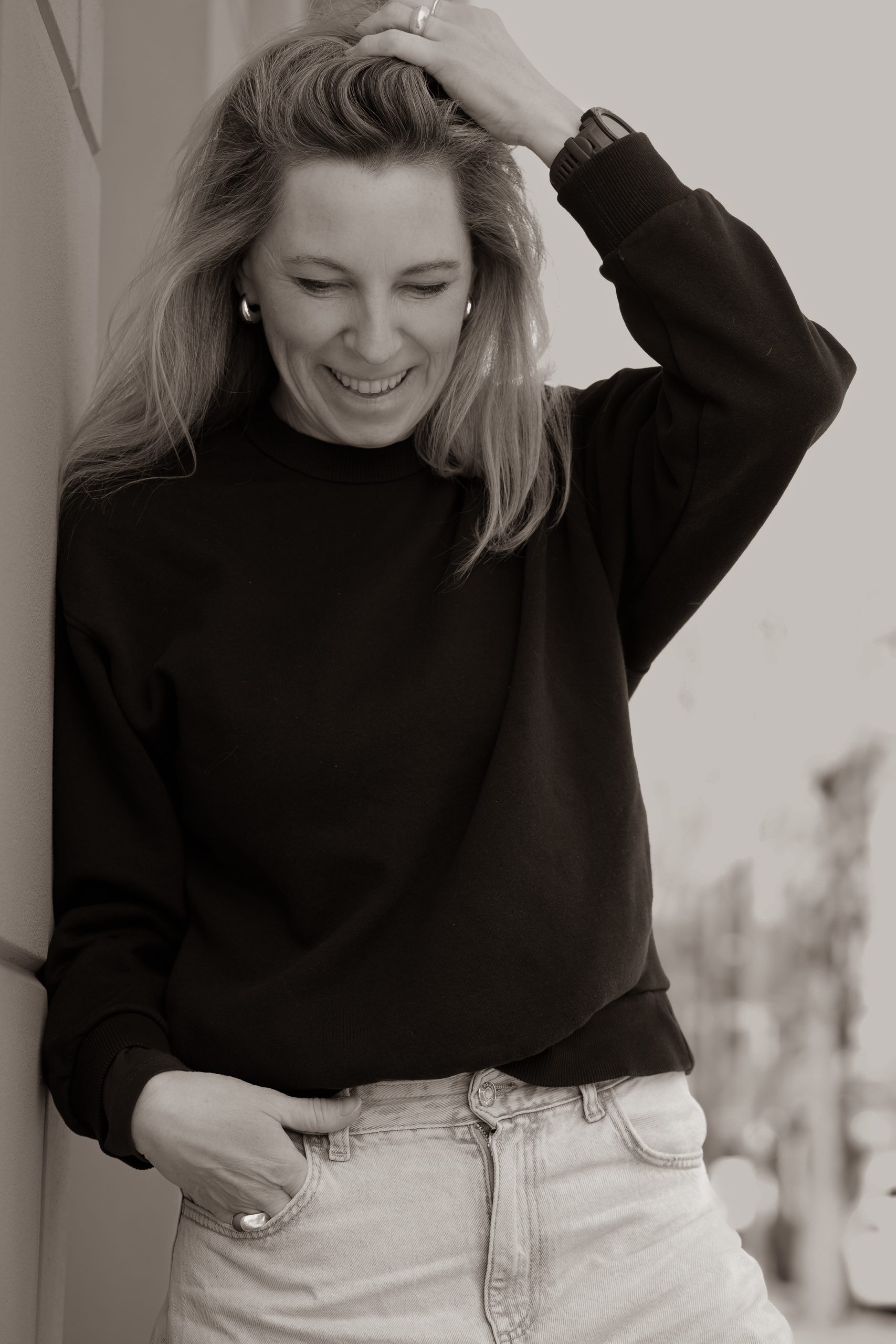"Spontane portretfoto van een lachende vrouw in casual outfit – natuurlijke en stijlvolle portretfotografie door By Iris van der Zwan in Westland."