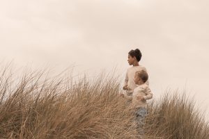 “Twee kinderen spelend in de duinen van ’s-Gravenzande, natuurlijke familiefoto tijdens een fotoshoot in het Westland, vastgelegd door ByIrisvdZwan in de regio Den Haag.”