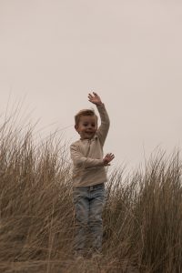 “Twee kinderen spelend in de duinen van ’s-Gravenzande, natuurlijke familiefoto tijdens een fotoshoot in het Westland, vastgelegd door ByIrisvdZwan in de regio Den Haag.”