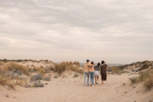 “Gezinsfotoshoot in de duinen van ’s-Gravenzande, Westland – liefdevol gezin dat samen richting zee wandelt, vastgelegd door ByIrisvdZwan in de natuur van de regio Den Haag.”