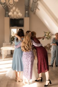 Bruidsfotografie Westland – een intiem moment van de bruid die haar vriendinnen omhelst tijdens de voorbereidingen, vastgelegd in warm licht door By Iris van der Zwan, bruidsfotograaf ’s-Gravenzande, regio den haag