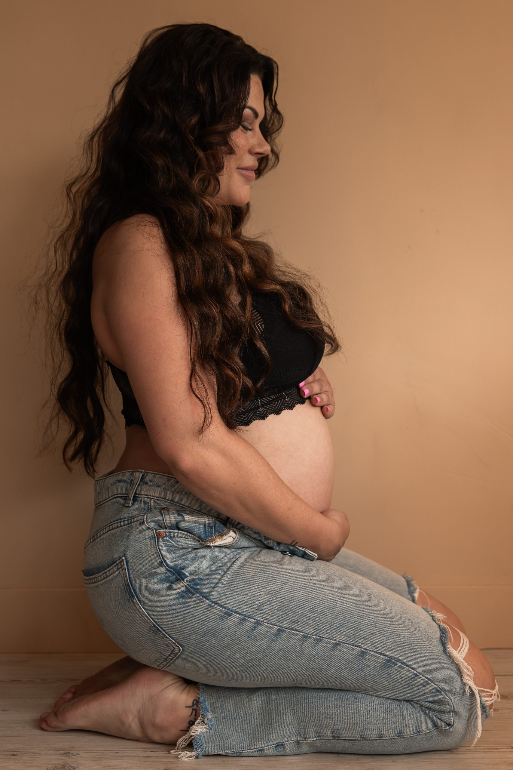 Zwanger portret van vrouw zittend op een blok in studio, zwangerschapsfotografie Westland, 's-Gravenzande, regio Den Haag door ByIrisvdZwan