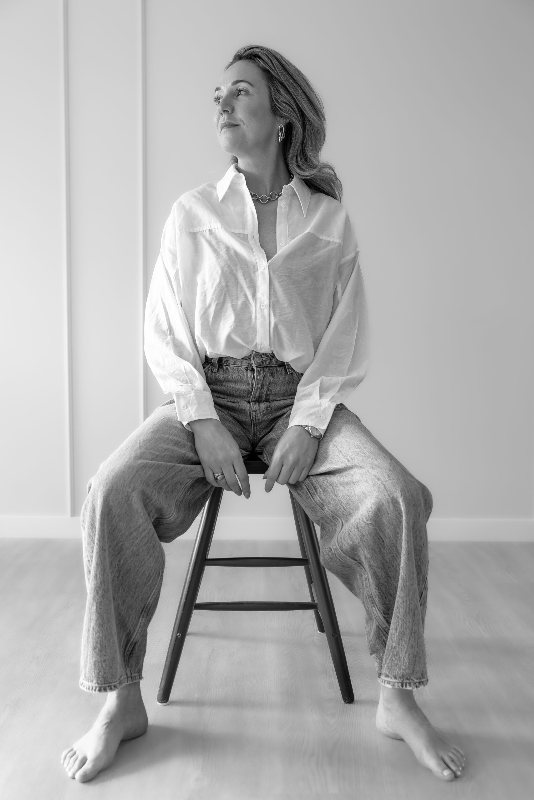“Branding fotoshoot vrouw in studio, minimalistisch zwart-wit portret met zachte lichtinval, portretfotografie voor vrouwen in ’s-Gravenzande regio Westland Den Haag”