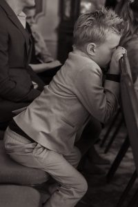 Bruidsfotograaf ByIrisVdZwan – klein jongetje in pakje tijdens bruiloft, onbewaakt momentje in zwart-wit | Westland regio Den Haag