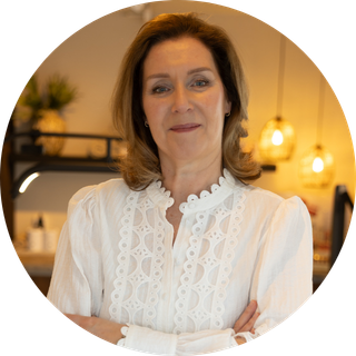 Portret van vrouwelijke ondernemer/fotograaf in lichte kleding, zittend op stoel binnenlocatie, warme en rustige uitstraling, brandingfoto vrouwelijk bedrijf, personal branding fotografie, natuurlijke portretfoto, ByIrisvdZwan, Westland, ’s-Gravenzande, regio Den Haag