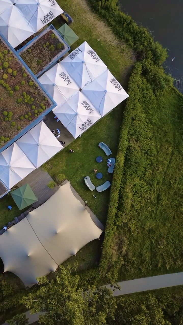 Dronefoto van een landelijke trouwlocatie met ceremonie-opstelling, stretchtent en buitenbar in het Westland, regio Den Haag. gemaakt door ByIrisvdZwan, bruidsfotograaf.